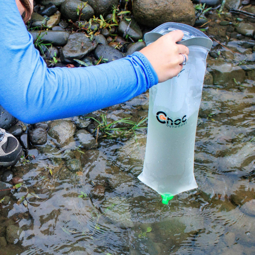 A Cnoc VectoX 28mm being used to collect water from a stream.