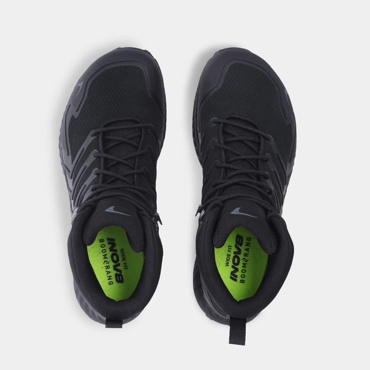 Birdseye view of black hiking boots with green insoles on a white background