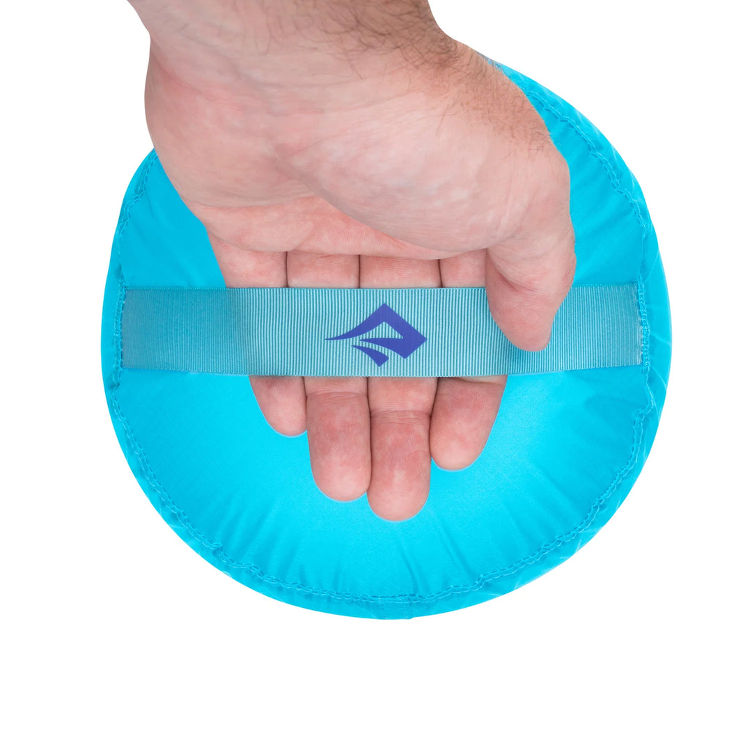 Hand holding a blue wristband with a logo on a white background