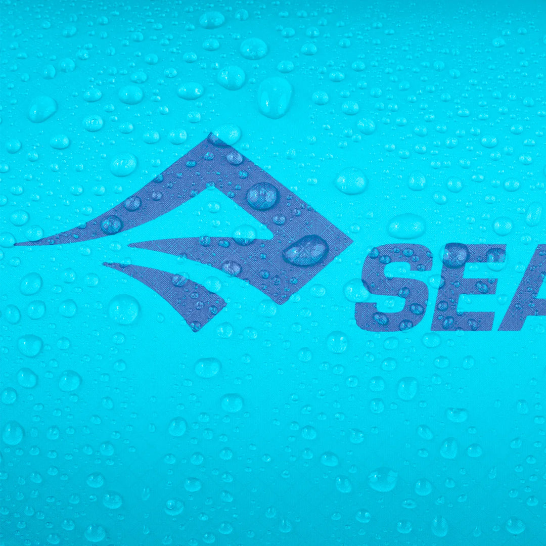 A close-up of a blue water-repellent surface with water droplets, featuring a partially visible dark blue logo that reads SEA.