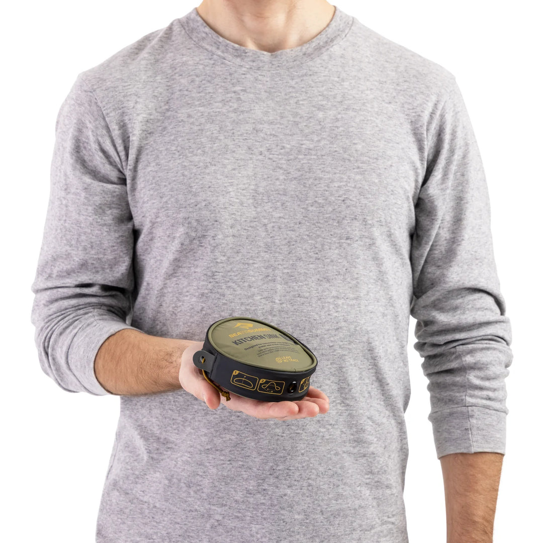 Person holding a black and green device against a white background