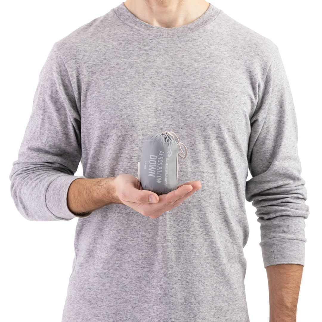 Person holding a slightly larger grey stuff sack in one cupped hand