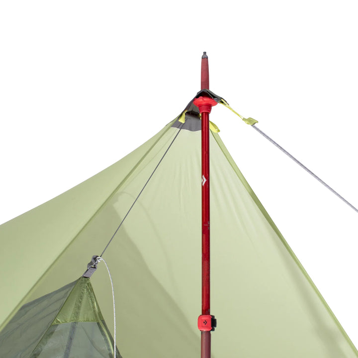 Green camping tent with a red pole on a white background