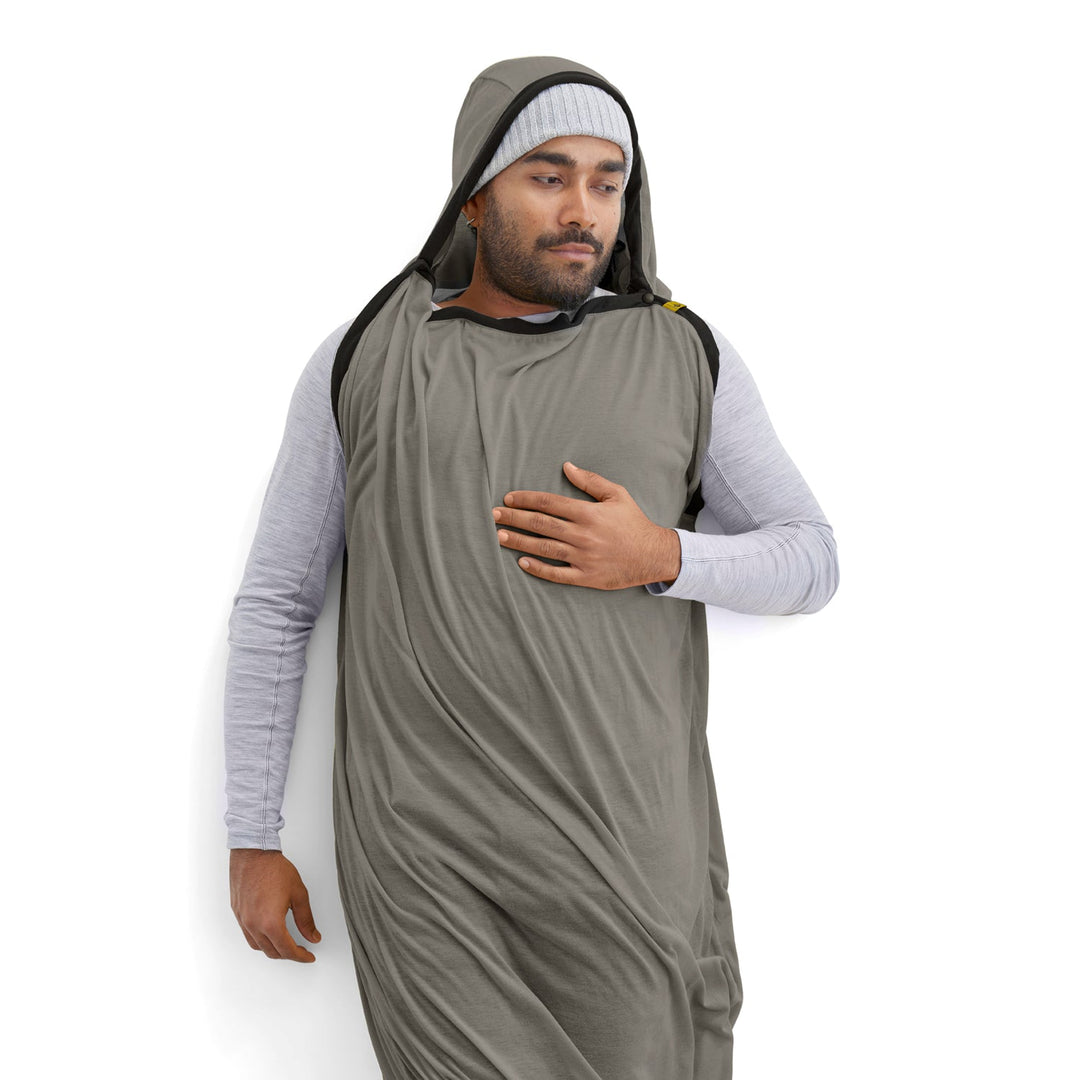 Man wearing a grey hooded sleeping bag liner on a white background