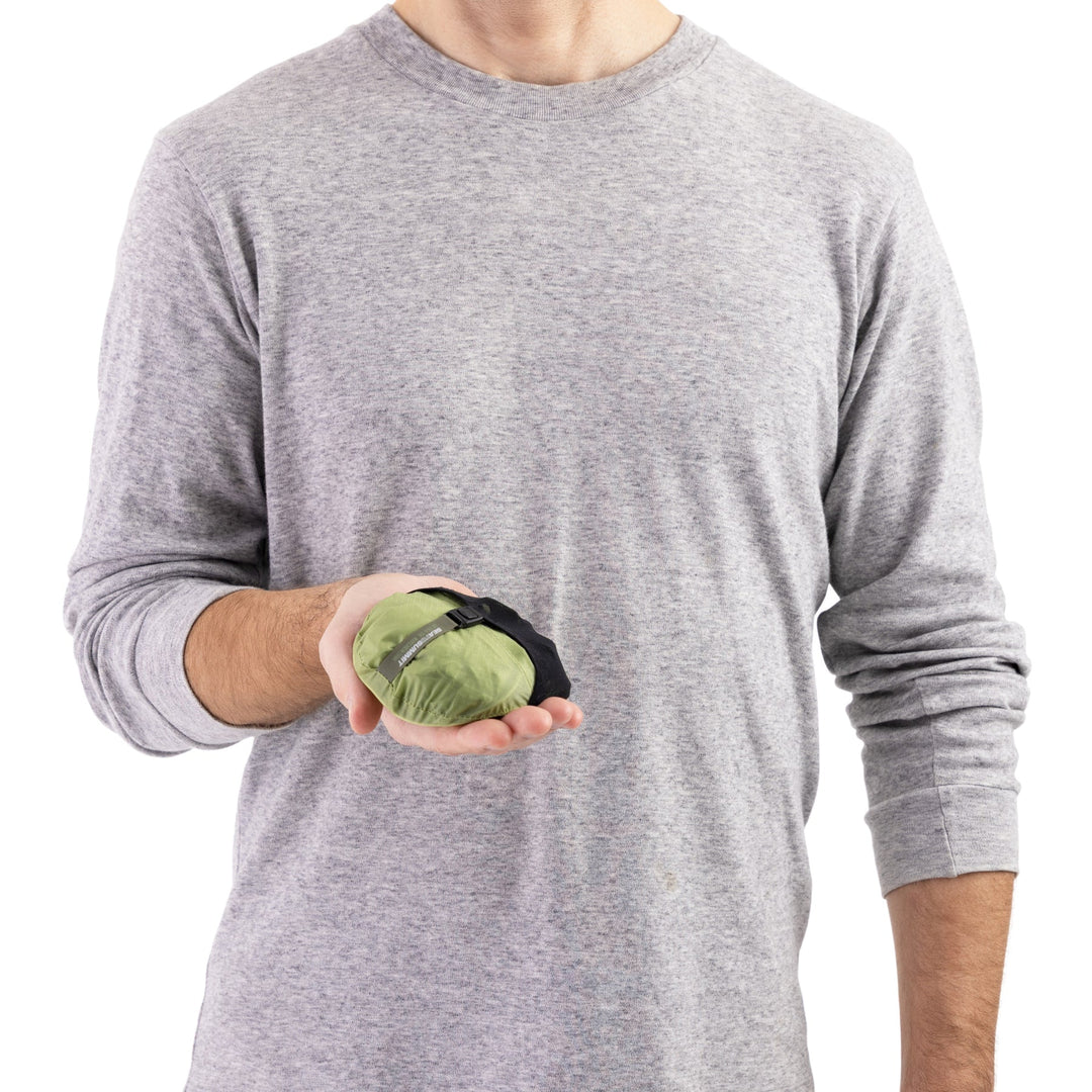Person holding a green and black stuff sack that fits in one hand