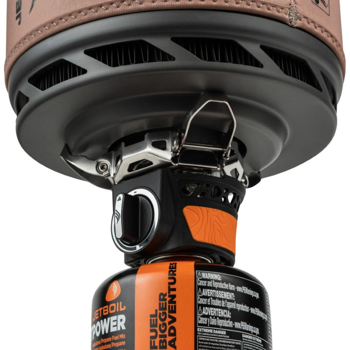 Close-up of a camping stove with a fuel canister attached on a white background