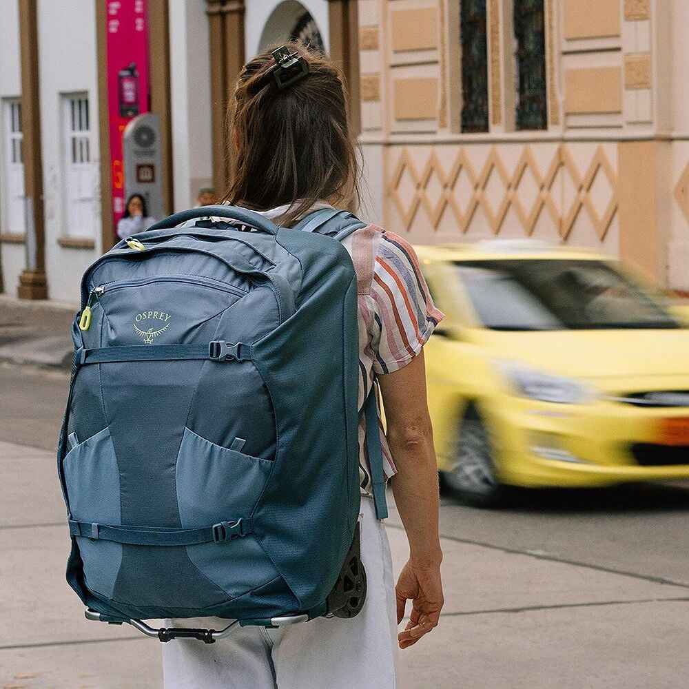Person with a large blue backpack walking on a street.