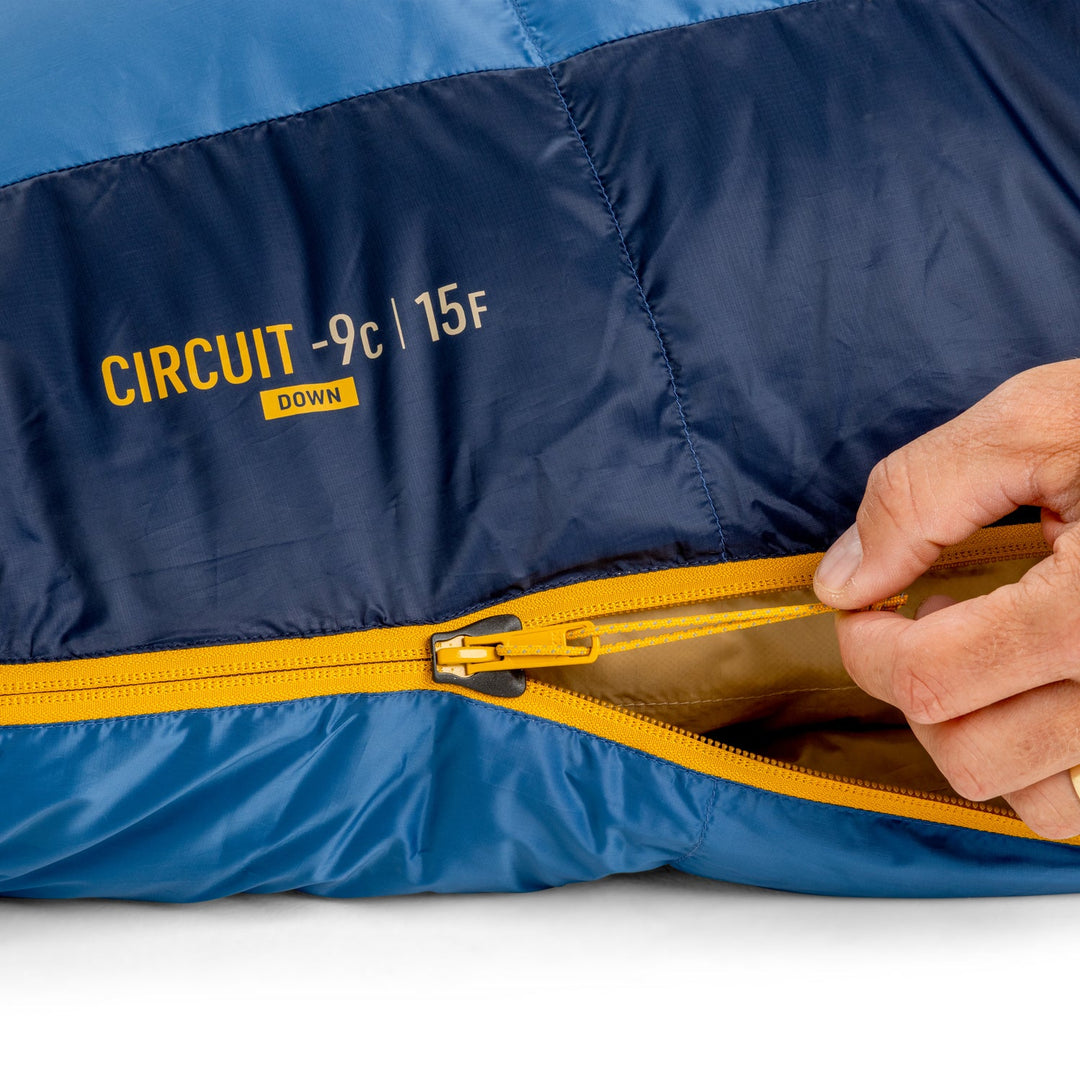 Blue sleeping bag with yellow zipper and 'Circuit' branding on a white background