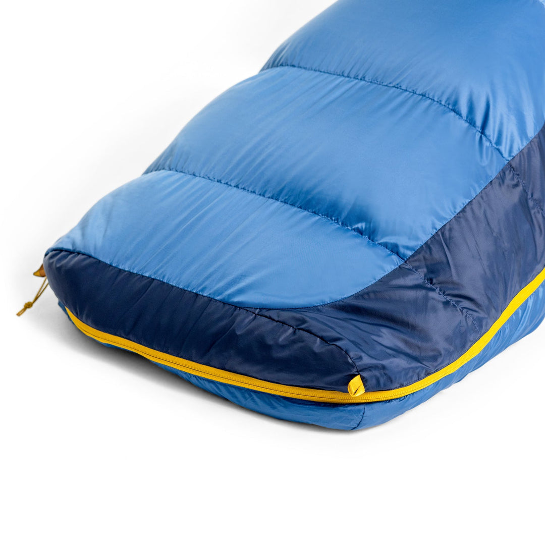 Blue and navy sleeping bag with yellow zipper on a white background