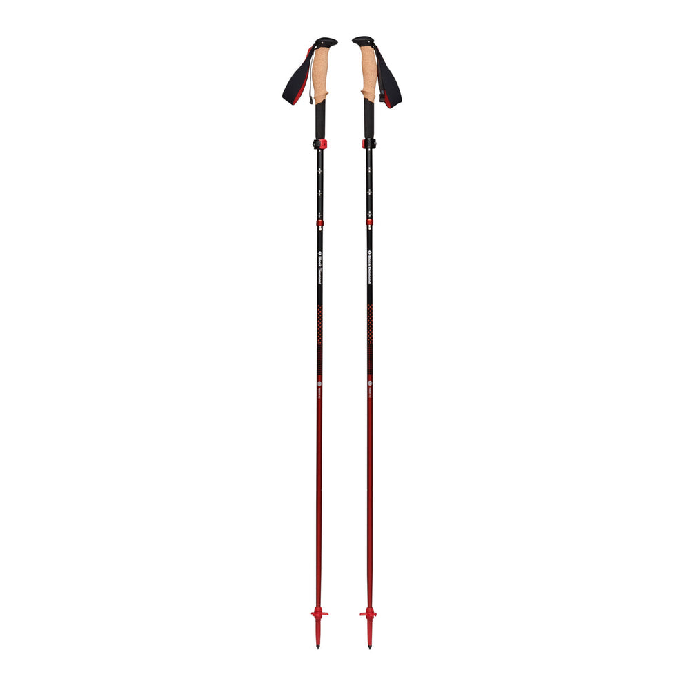 Black trekking poles with red detailing, extended, on a white background
