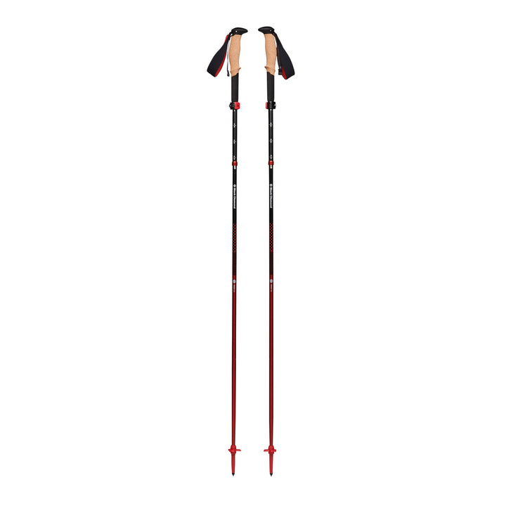 Black trekking poles with red detailing, extended, on a white background