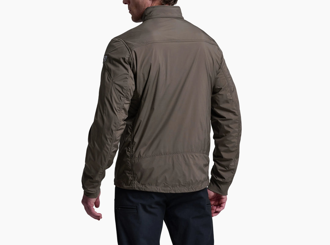 Man wearing a brown jacket and jeans viewed from behind on a dark background