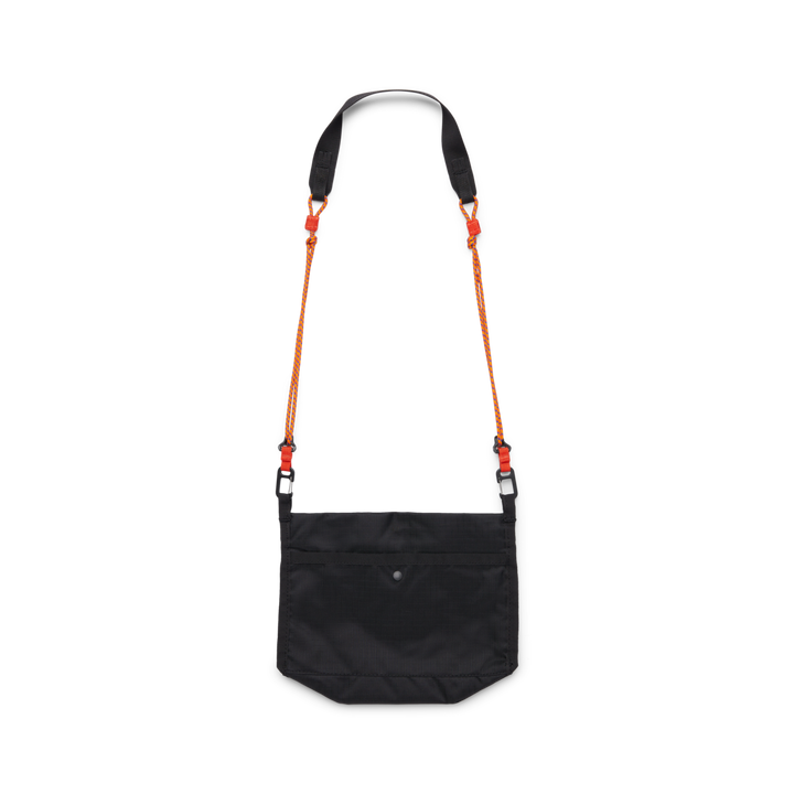 Black cross body bag with a strap made from orange cord viewed from behind on a white background
