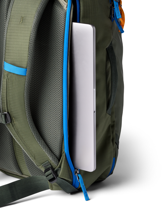 Close up of a zippered laptop sleeve in a green backpack with a laptop half inside
