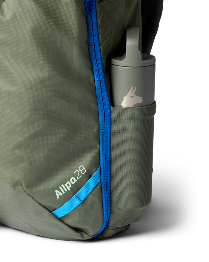Close up of mesh bottle pocket on a green backpack containing a Cotopaxi water bottle 