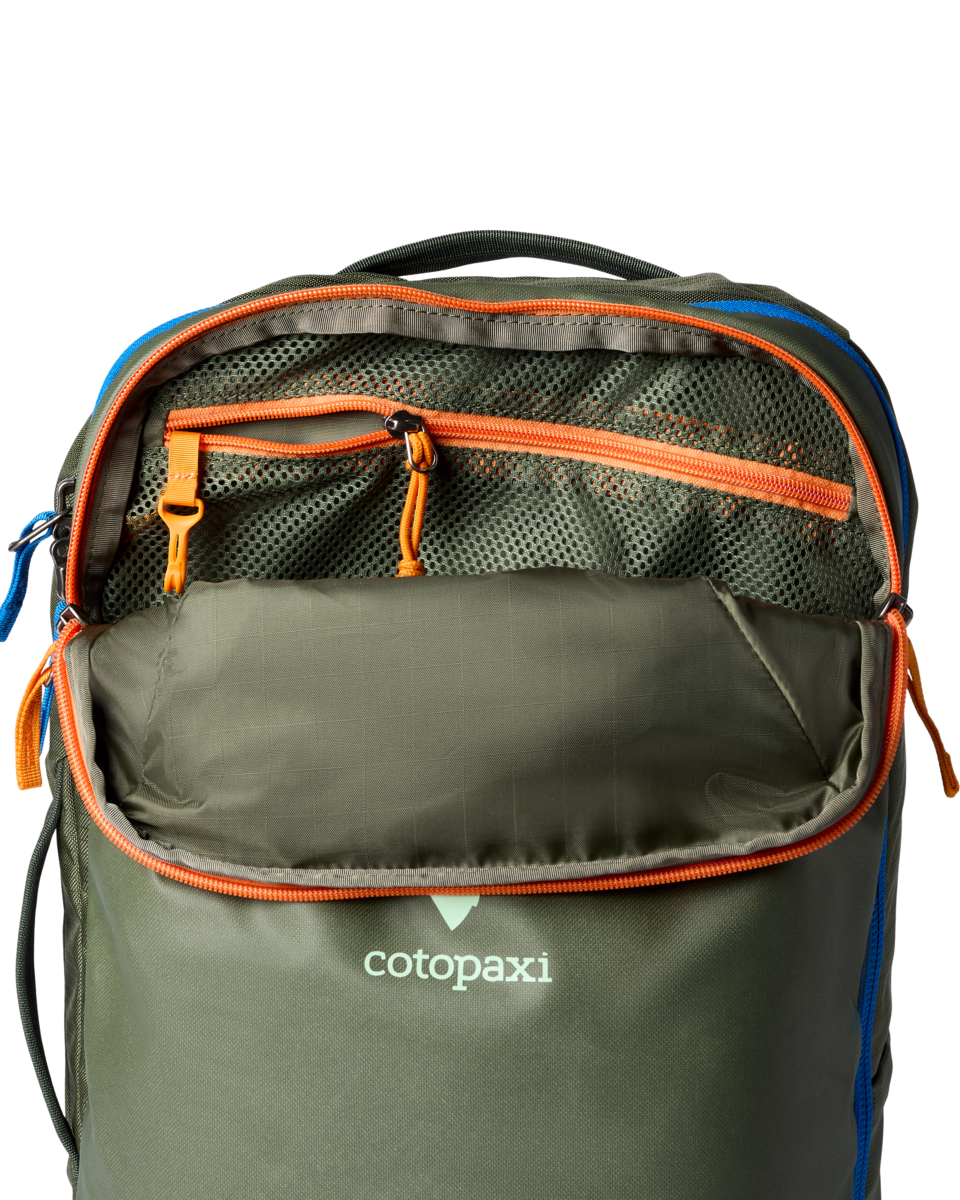 Green backpack with orange and blue highlights, unzipped, with mesh pocket and key hook