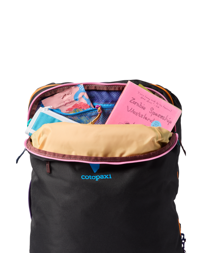 Black backpack with colorful items inside, featuring the Cotopaxi brand.