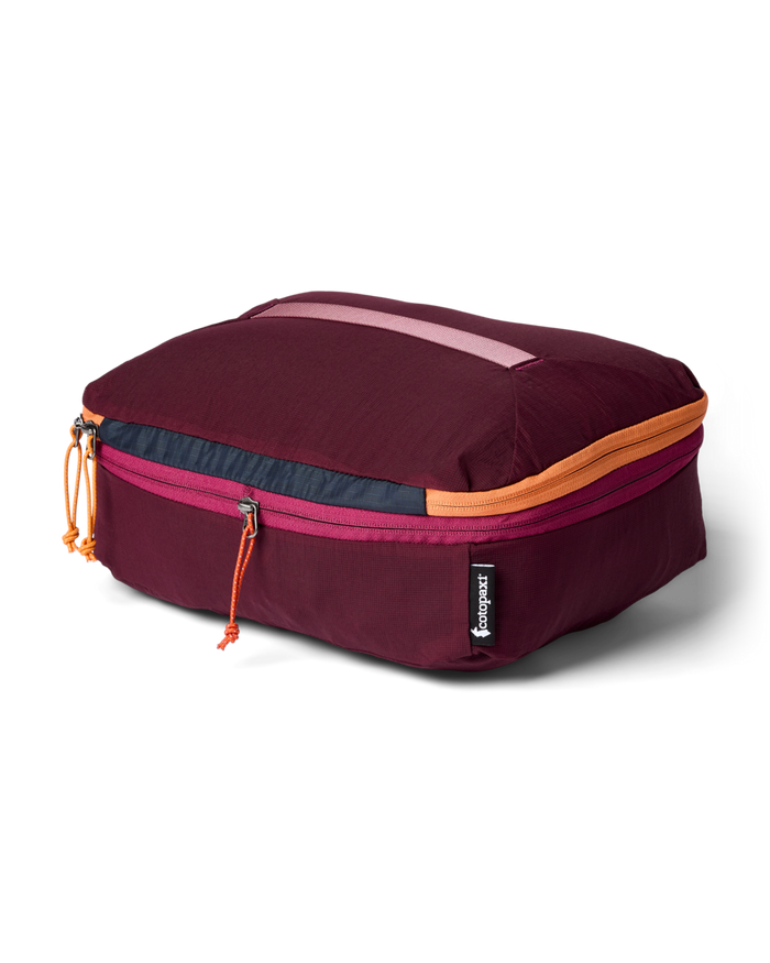 Maroon travel packing cube with colorful zippers on a white background