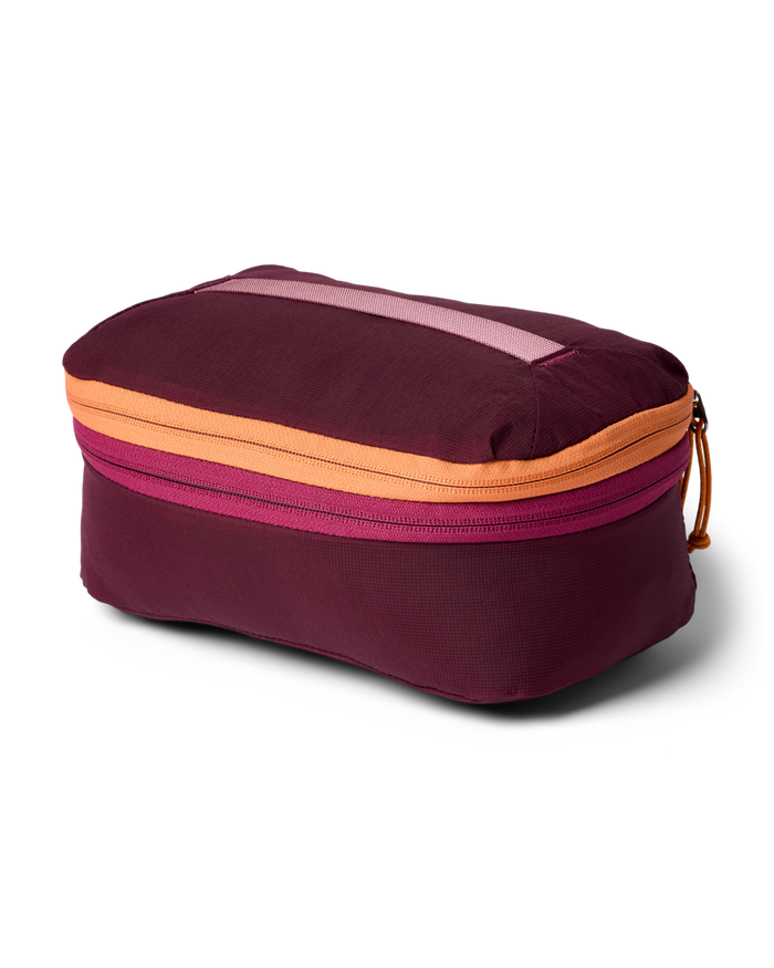 Maroon packing cube with orange accents on a white background