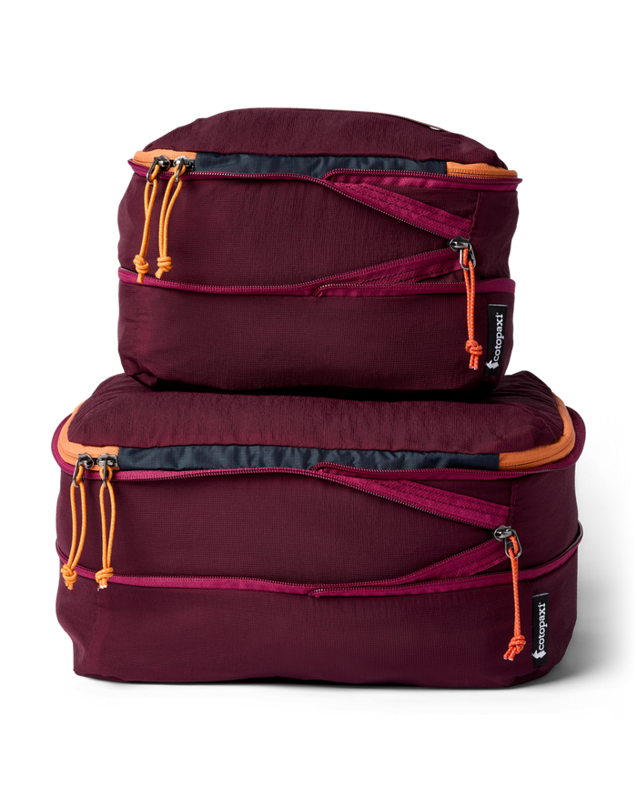 Two maroon packing cubes with orange zippers on a white background