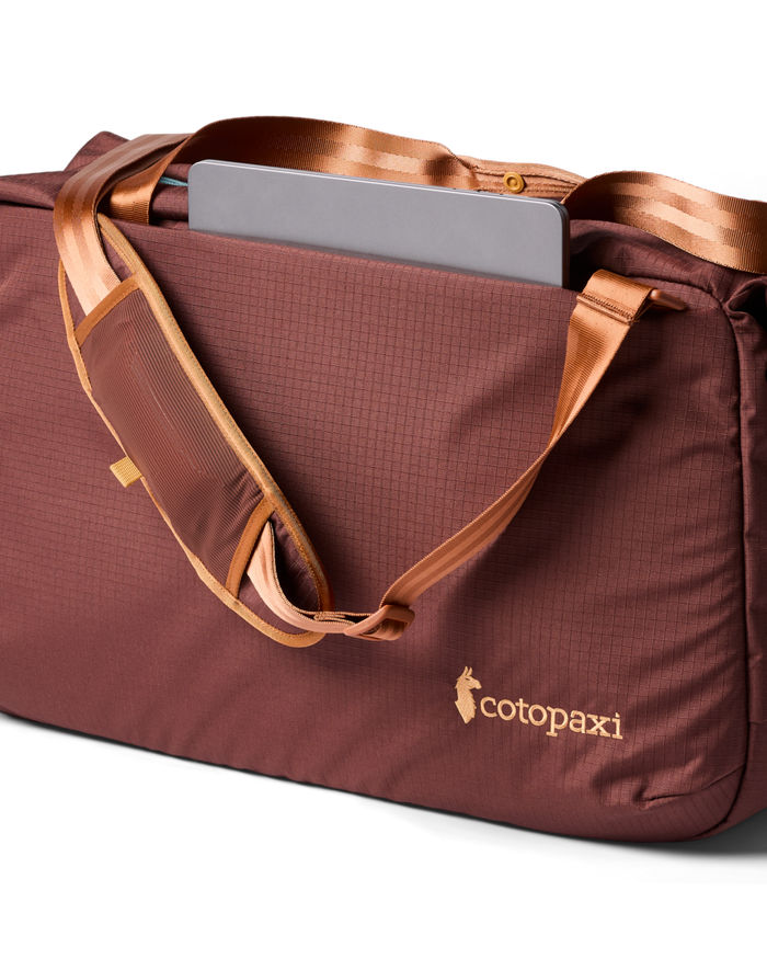 Brown duffel bag with gold accents and a visible Cotopaxi logo on a white background