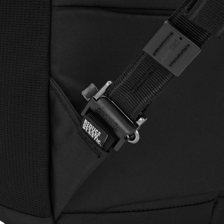Close up of a releasable clip at the bottom attachment of a backpacks shoulder strap