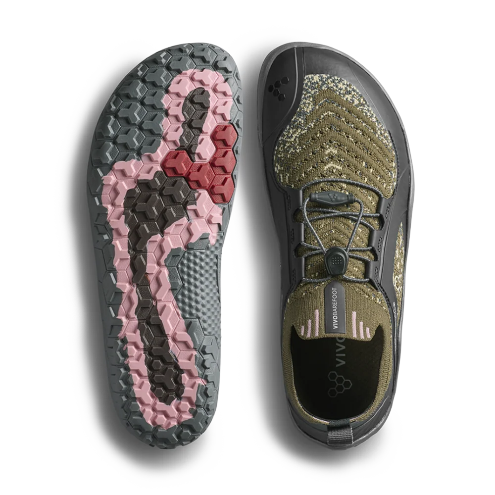A pair of minimalist slip-on shoes shown from the top and bottom on a white background. One shoe displays its textured olive green and black upper with a dial closure, and the other shows the sole with a pink and dark gray tread pattern.