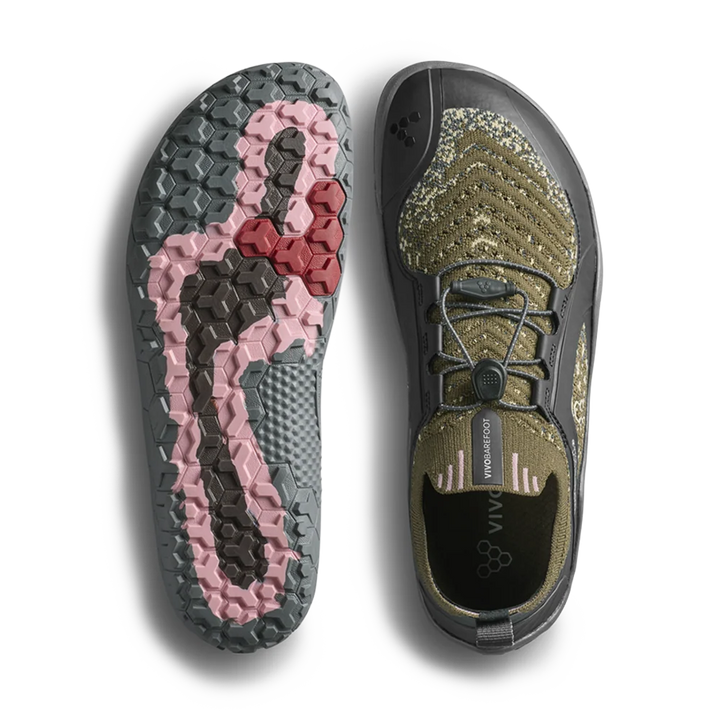 A pair of minimalist slip-on shoes shown from the top and bottom on a white background. One shoe displays its textured olive green and black upper with a dial closure, and the other shows the sole with a pink and dark gray tread pattern.
