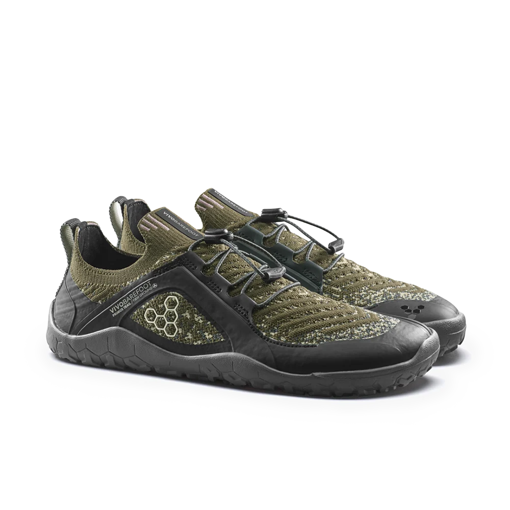 A pair of low-top athletic shoes in olive green and black, featuring a knit upper, hook-and-loop strap closure, and a textured black sole, photographed on a clean white background.
