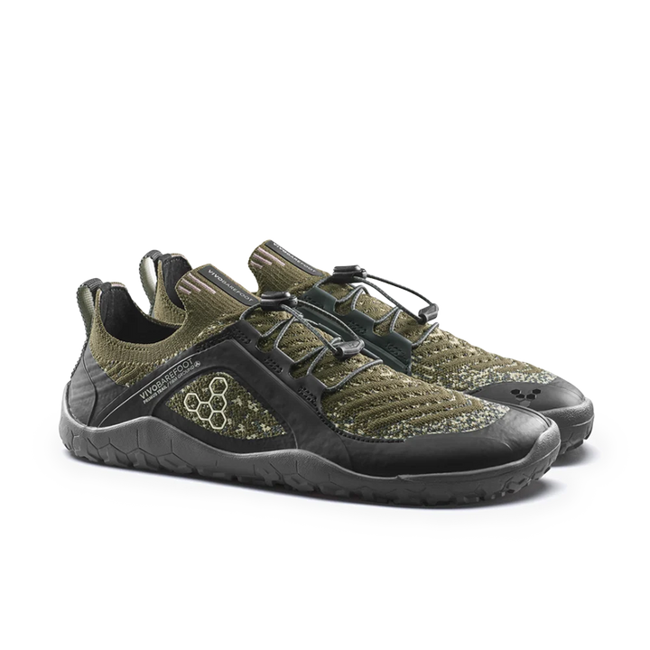 A pair of low-top athletic shoes in olive green and black, featuring a knit upper, hook-and-loop strap closure, and a textured black sole, photographed on a clean white background.