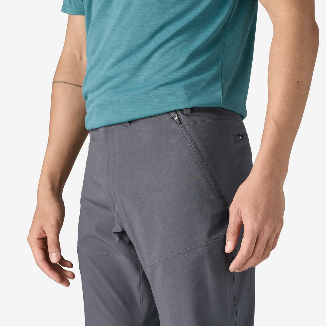 Close of a person wearing dark gray pants showing a zippered pocket