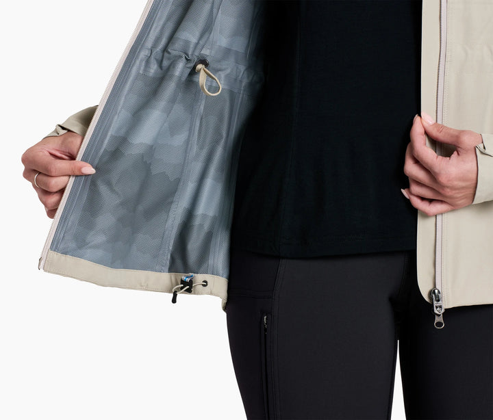 Lower torso of person holding open a raincoat showing drawcords at waist and hip