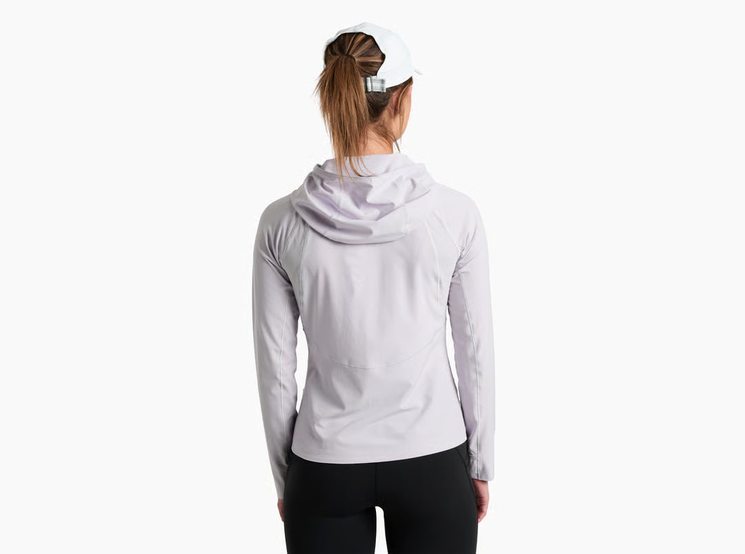 Woman wearing a light gray hoodie and black leggings on a white background
