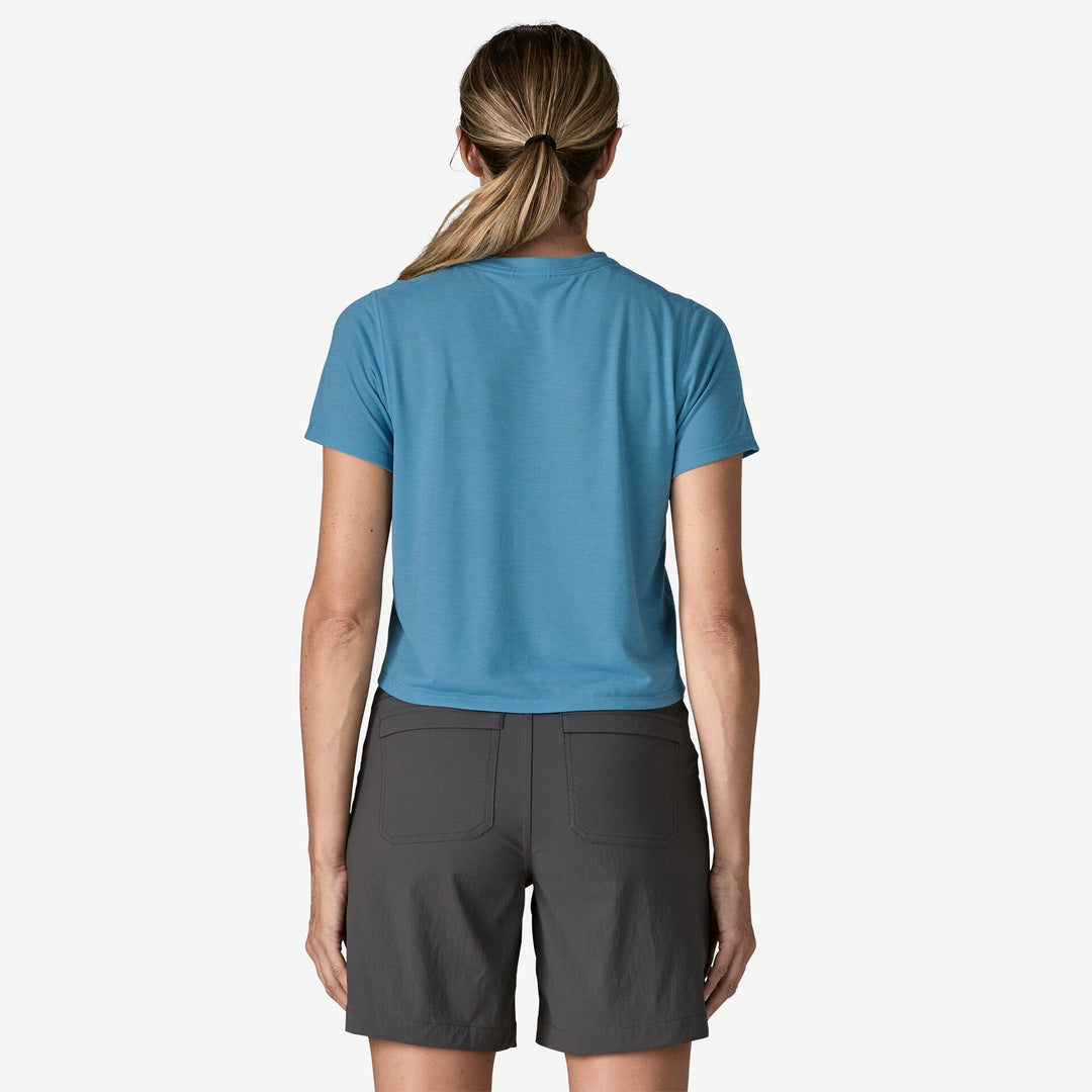 Women wearing a blue shirt and grey shorts on a white background