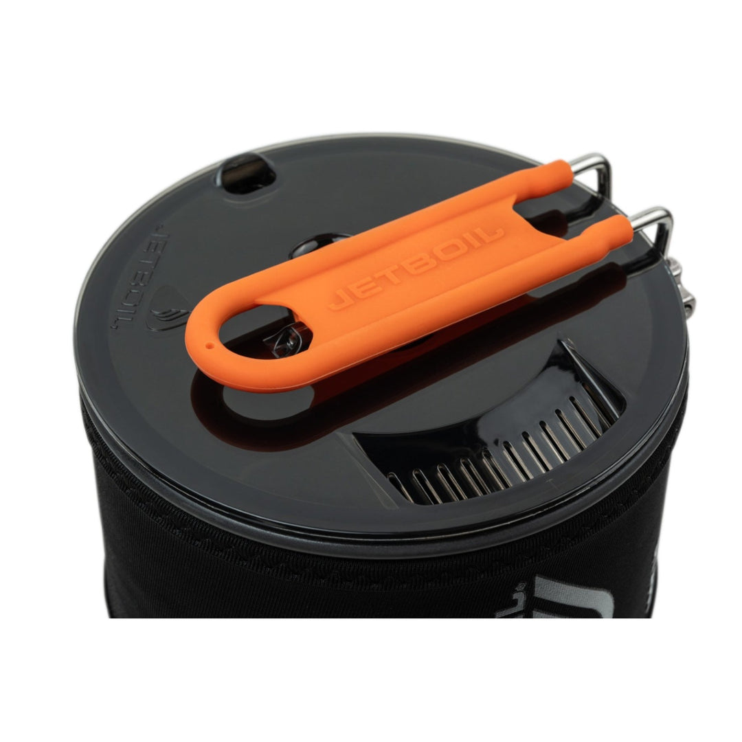 Black pot with orange handle on a white background