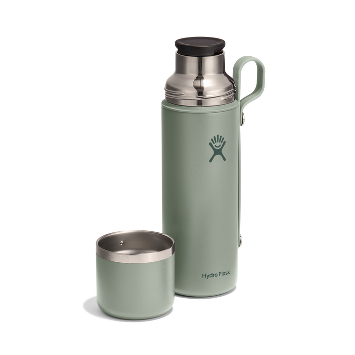 Green thermos with lid removed on a white background