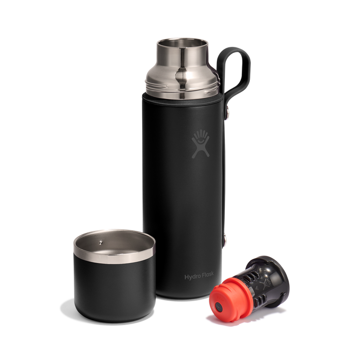 Black thermos bottle with lid and valve style cap removed and lying next to it