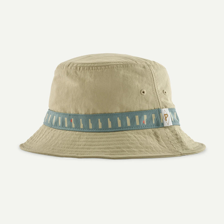 Beige bucket hat with a blue band featuring white designs on a light gray background