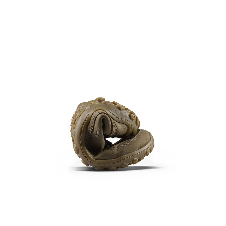 A single vivo barefoot shoe rolled up to show the flexibility of the shoe. The shoe is olive green/tan and has a tan textured out sole. Photo is on a white background. 