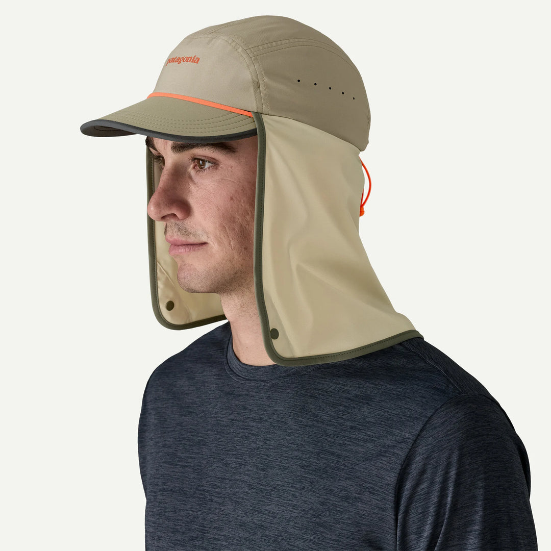 Person wearing a beige cap with a neck flap on a white background