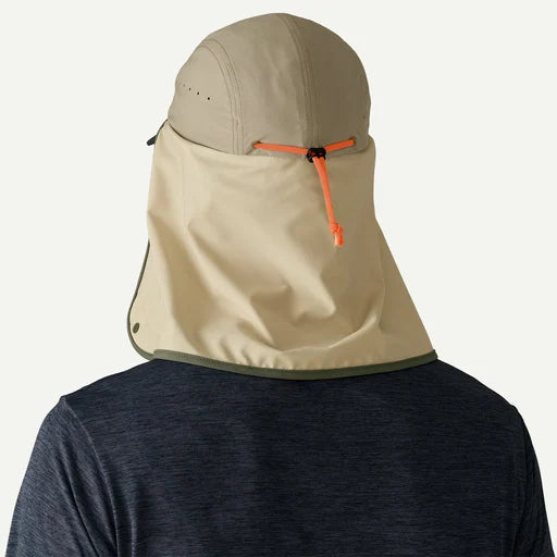 Beige hood with orange zipper on a person wearing a dark shirt against a white background