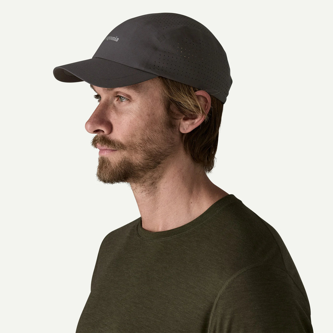 Man wearing a black cap and green shirt on a white background