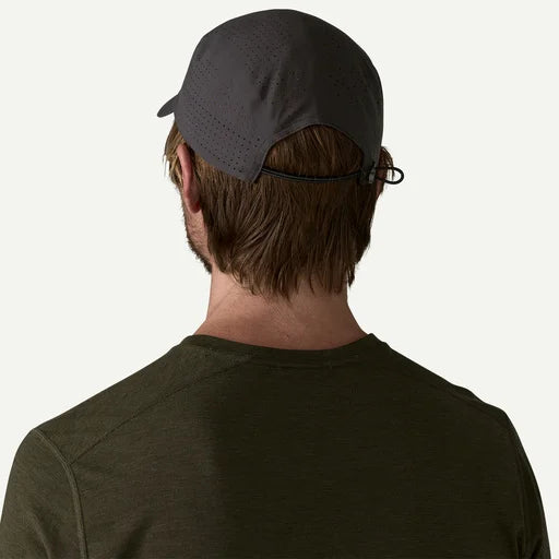Person wearing a dark cap and shirt on a white background