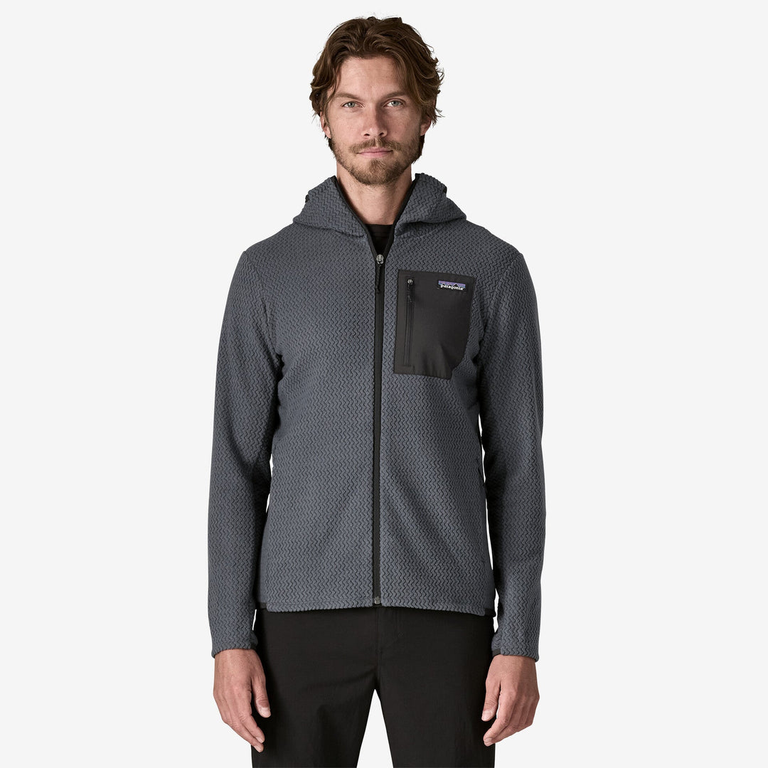 Man wearing dark grey hooded fleece on white background.