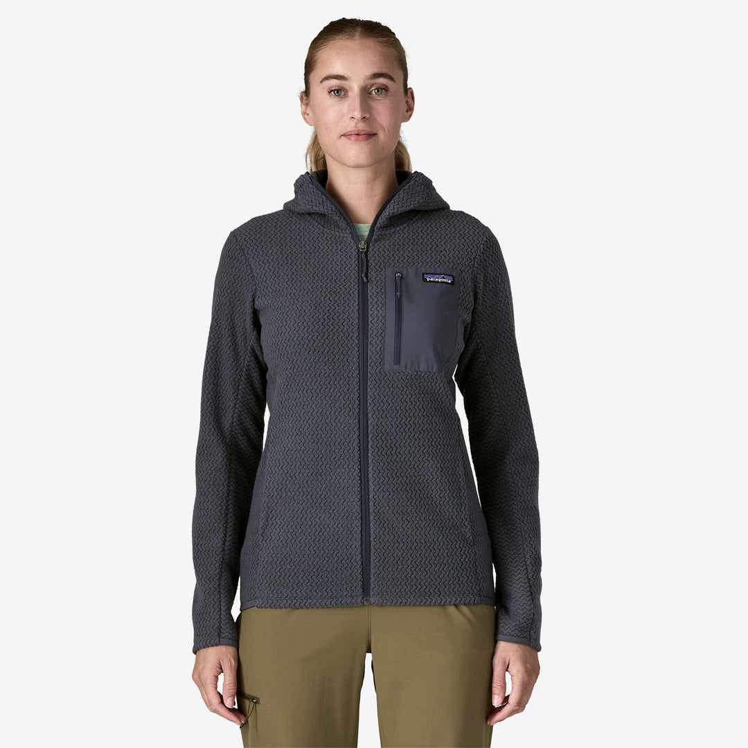 Person wearing a dark gray hooded jacket with a visible brand logo on a white background