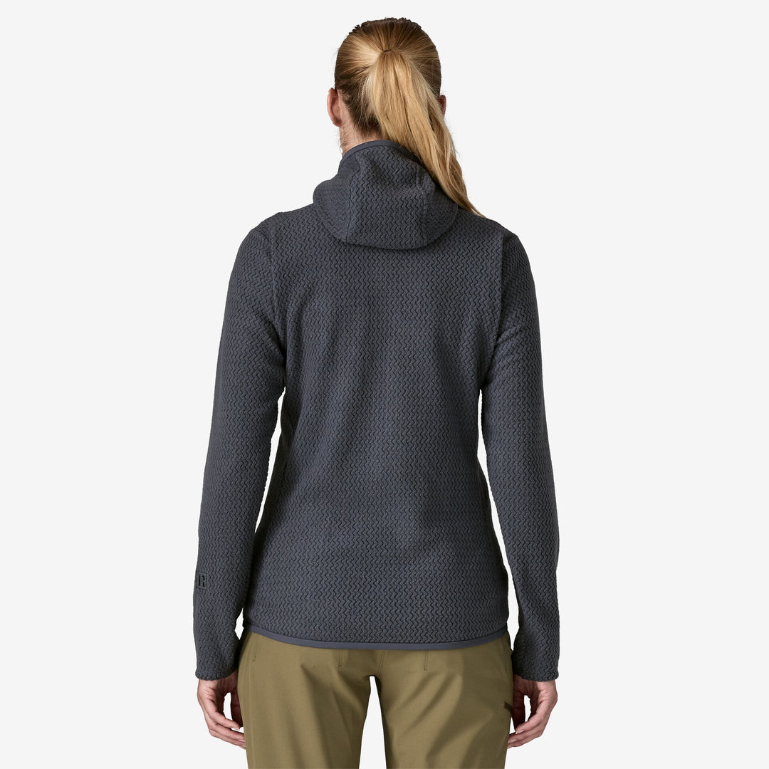 Back view of woman wearing dark grey hooded fleece, on a white background