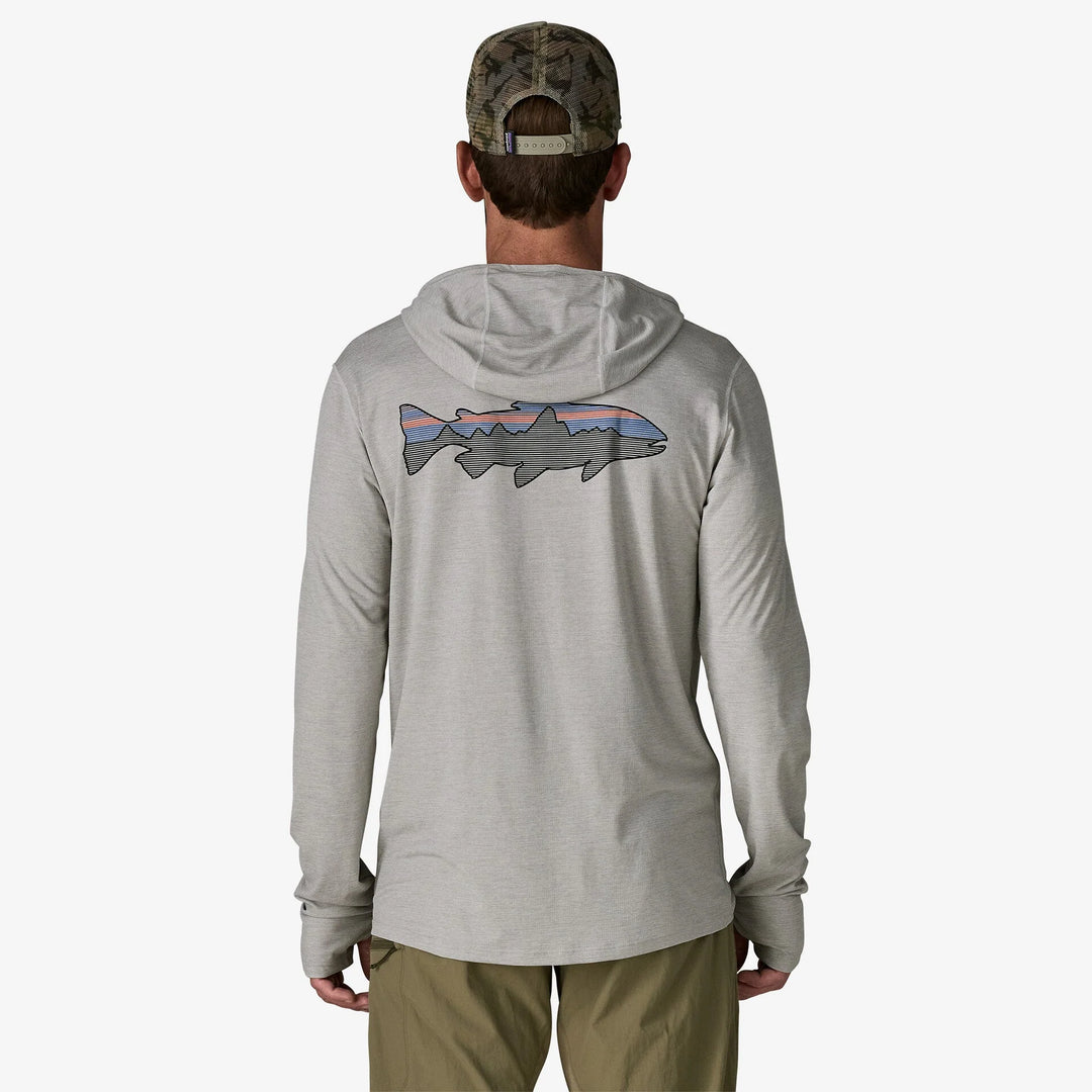 Person wearing a gray hoodie with a fish design on the back, standing against a white background