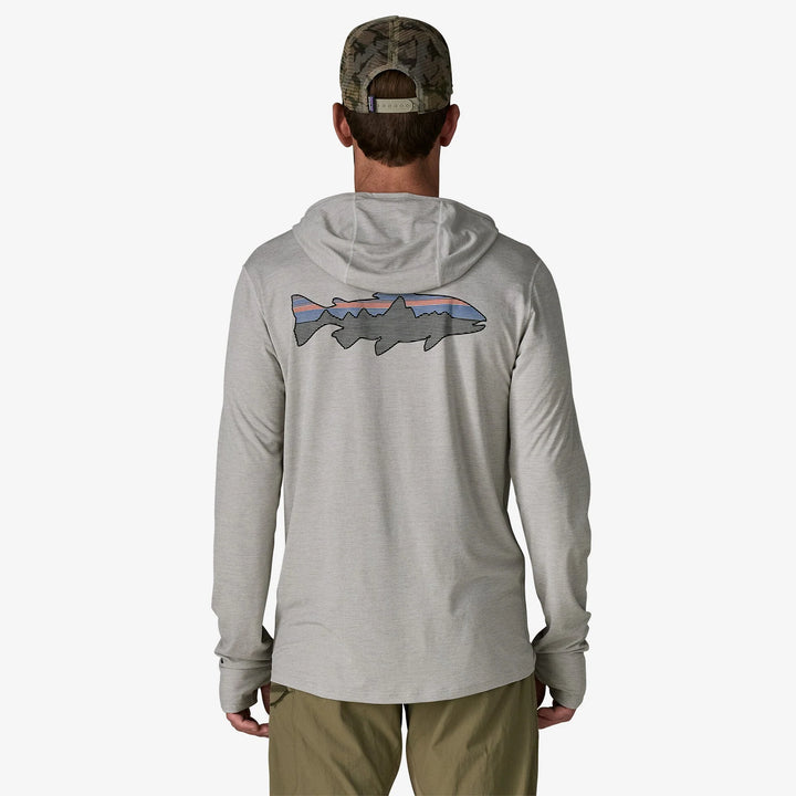 Person wearing a gray hoodie with a fish design on the back, standing against a white background