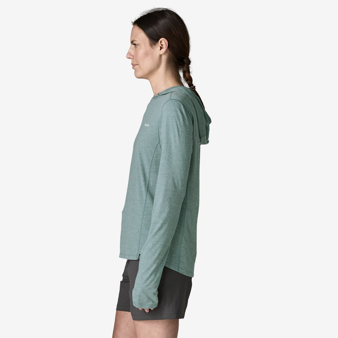 Woman wearing a green hoodie and grey shorts on a white background