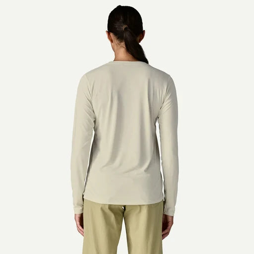 Person wearing a beige long-sleeve shirt and pants on a white background